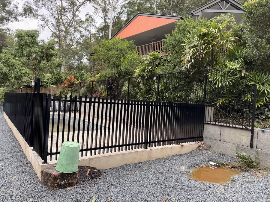 Black aluminium flat-top fence and privacy screen on a besser block retaining wall