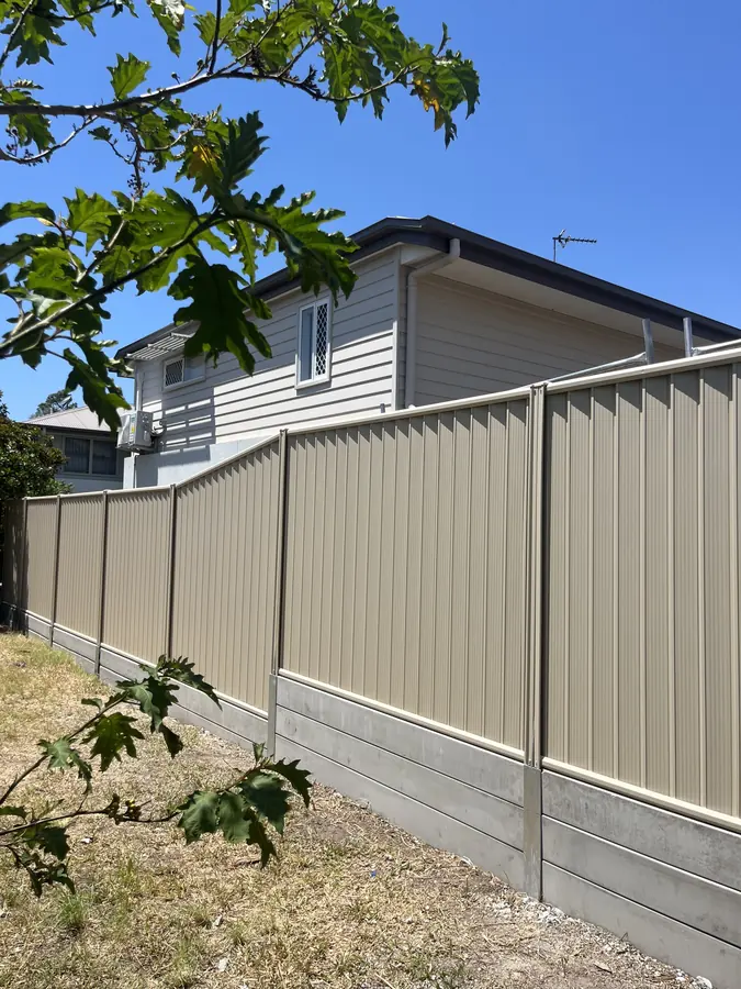 Colorbond fence with decorative castellated top and concrete plinth along a side boundary