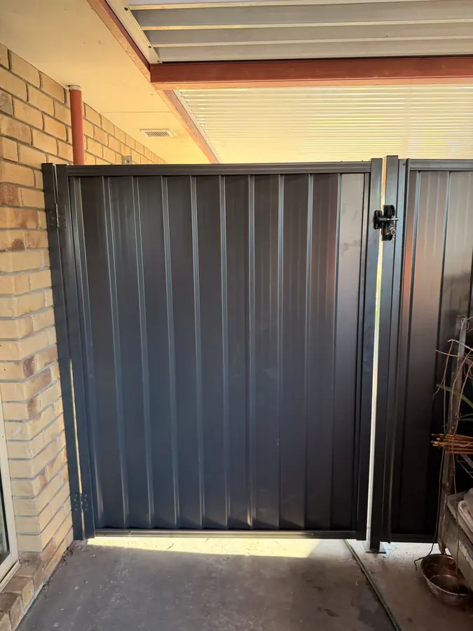 Colorbond gate hung off a brick wall with a self-closing latch
