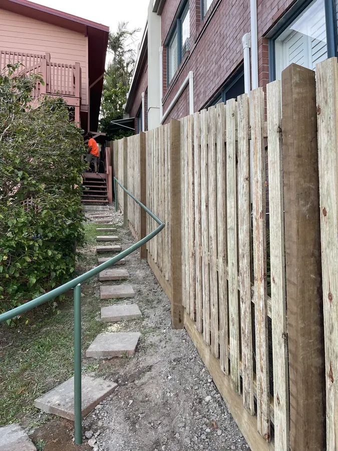 Hardwood paling fence under construction beside a garden stairway